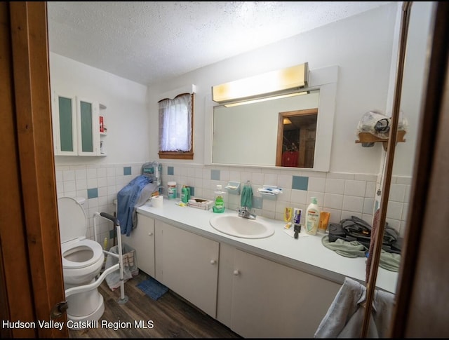 125 County Route 26a, Stuyvesant, NY 12106 - bathroom with wood finished floors, vanity, a textured ceiling, tile walls, and a wainscoted wall