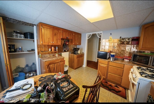 125 County Route 26a, Stuyvesant, NY 12106 - kitchen featuring stainless steel microwave, gas range gas stove, a drop ceiling, brown cabinetry, and light flooring