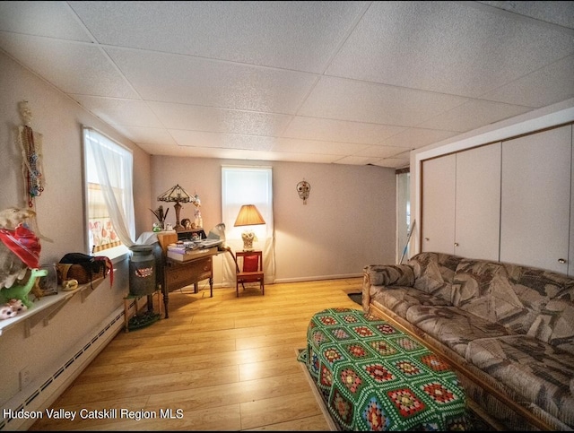 125 County Route 26a, Stuyvesant, NY 12106 - living room with a baseboard heating unit, light wood-type flooring, and a paneled ceiling