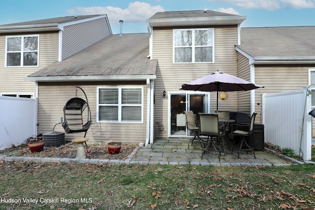 rear view of property with a patio, roof with shingles, cooling unit, fence, and a lawn