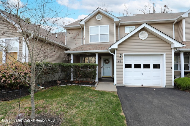 view of front of property with a shingled roof, a garage, a front yard, and driveway