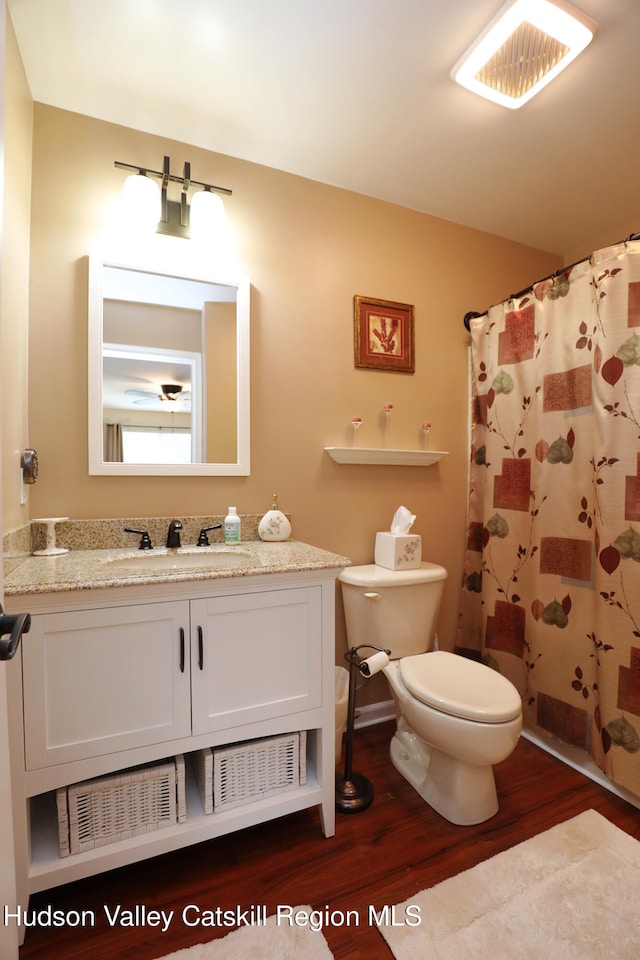 full bathroom featuring vanity, visible vents, toilet, curtained shower, and wood finished floors
