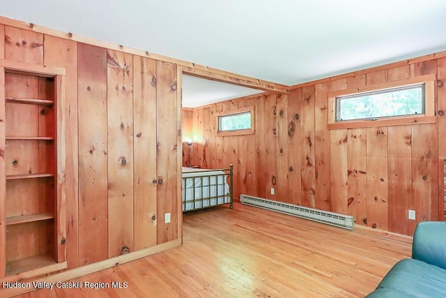 32 Harvey Mountain Rd, Austerlitz, NY 12017 - living area featuring a baseboard heating unit, wood finished floors, wooden walls, and healthy amount of natural light