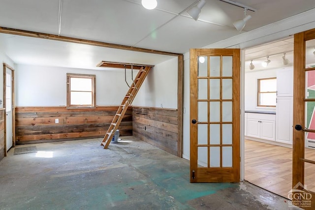 32 Harvey Mountain Rd, Austerlitz, NY 12017 - empty room featuring track lighting, wood walls, unfinished concrete floors, and wainscoting