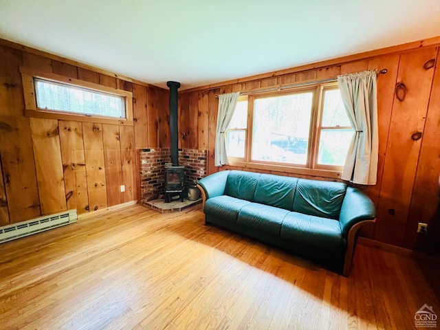 32 Harvey Mountain Rd, Austerlitz, NY 12017 - living room with a wood stove, light wood-style floors, healthy amount of natural light, wood walls, and a baseboard radiator