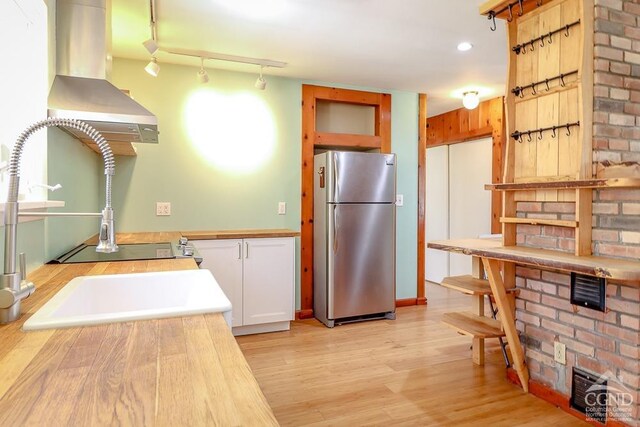 32 Harvey Mountain Rd, Austerlitz, NY 12017 - kitchen with freestanding refrigerator, light wood-style floors, white cabinets, and ventilation hood