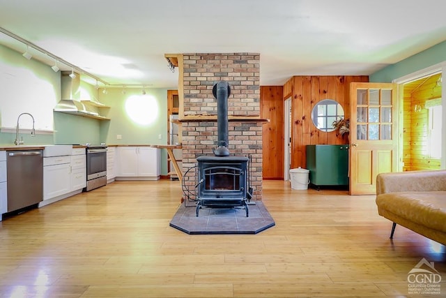 32 Harvey Mountain Rd, Austerlitz, NY 12017 - living area with a wood stove, wood walls, and light wood-style floors
