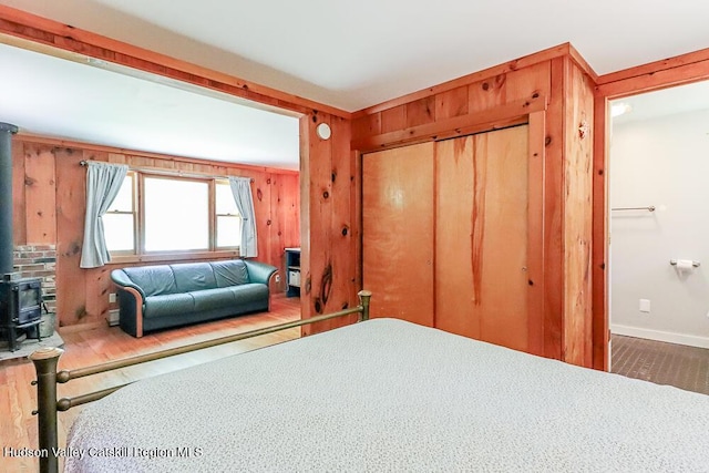 32 Harvey Mountain Rd, Austerlitz, NY 12017 - bedroom with a wood stove, a closet, and wooden walls