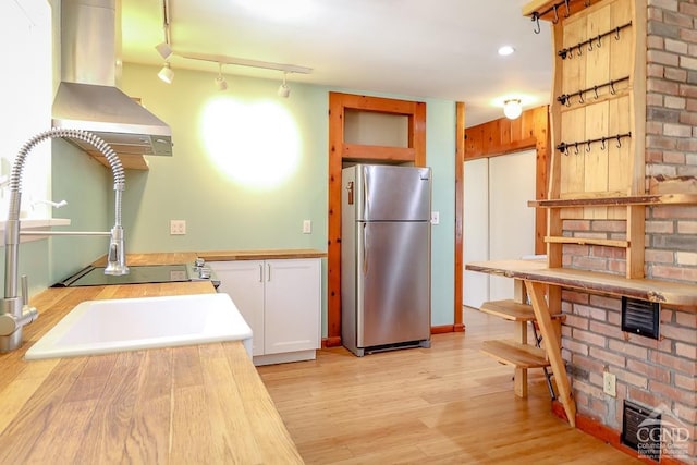 32 Harvey Mountain Rd, Austerlitz, NY 12017 - kitchen with freestanding refrigerator, exhaust hood, light wood-style flooring, and white cabinets