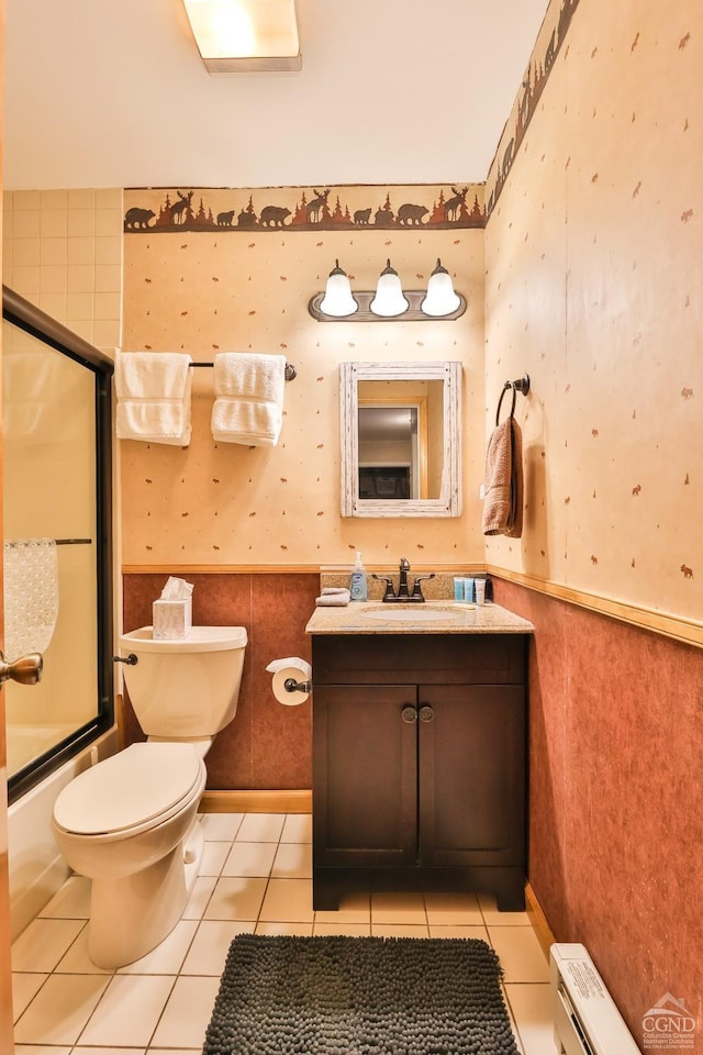 full bath featuring a wainscoted wall, vanity, toilet, bath / shower combo with glass door, and wallpapered walls