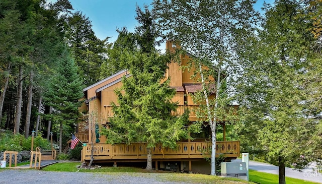 rear view of house with a wooden deck and a chimney