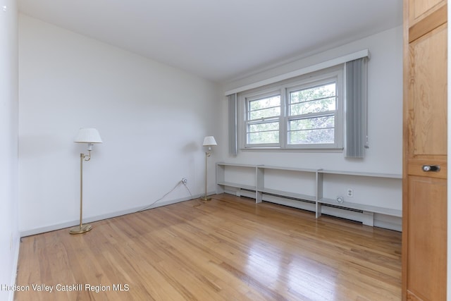 spare room with light hardwood / wood-style floors and a baseboard radiator