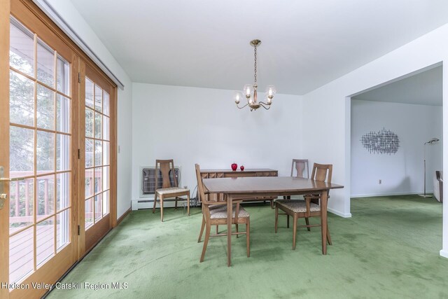 carpeted dining room featuring a baseboard heating unit and a notable chandelier