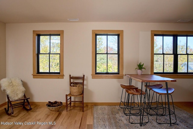 dining space featuring baseboards, visible vents, and a healthy amount of sunlight