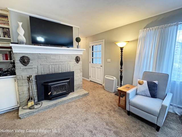 carpeted living room featuring a fireplace and a healthy amount of sunlight