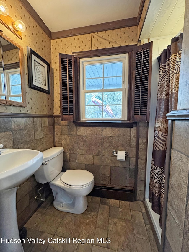 bathroom featuring toilet, a shower with shower curtain, tile walls, and a wealth of natural light