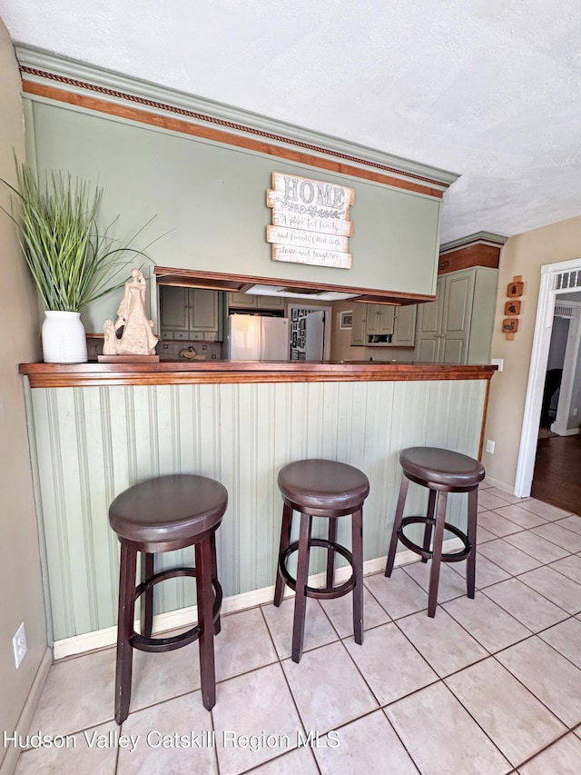 kitchen with white refrigerator, a breakfast bar area, and kitchen peninsula