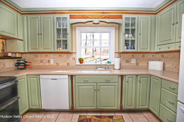 kitchen featuring tasteful backsplash, dishwasher, sink, range with two ovens, and light tile patterned floors