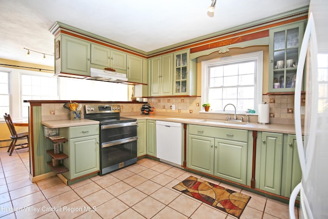 kitchen featuring sink, light tile patterned floors, white appliances, and green cabinetry