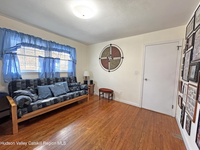 living room with hardwood / wood-style floors, a fireplace, and a textured ceiling