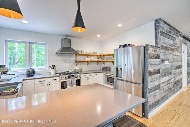 158 Rivka Rd, Saugerties, NY 12477 - kitchen with open shelves, appliances with stainless steel finishes, light wood-style floors, wall chimney exhaust hood, and white cabinetry