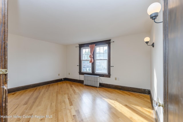 unfurnished room with wood-type flooring and radiator