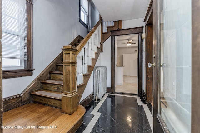 stairs featuring ceiling fan