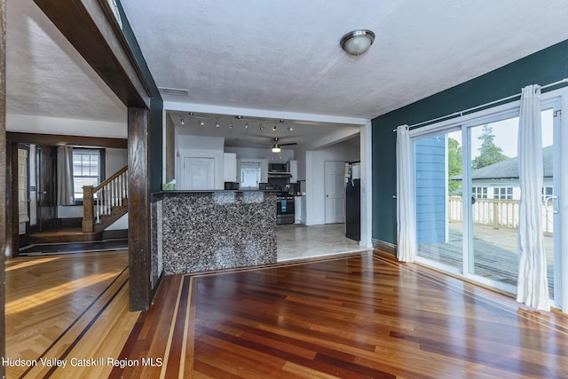 interior space featuring a wealth of natural light, hardwood / wood-style floors, ceiling fan, and a textured ceiling