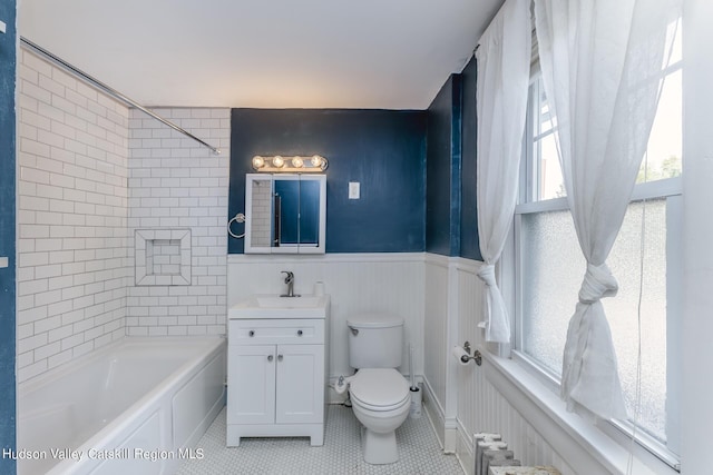 full bathroom with vanity, tiled shower / bath combo, tile patterned flooring, radiator heating unit, and toilet