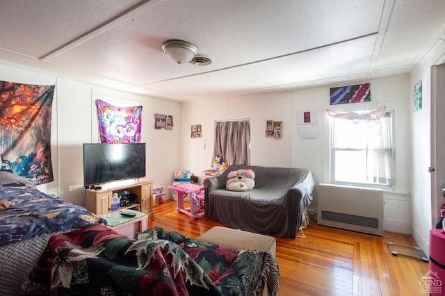 29 Railroad Ave, Chatham, NY 12037 - living room with hardwood / wood-style flooring, a textured ceiling, and heating unit