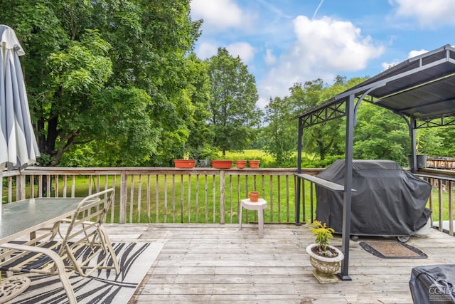 deck with grilling area, a lawn, and outdoor dining area