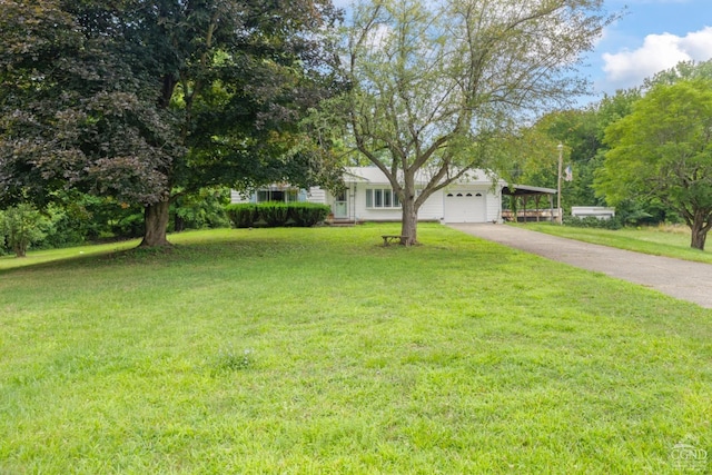 view of front of property featuring driveway, a front lawn, a garage, and a carport