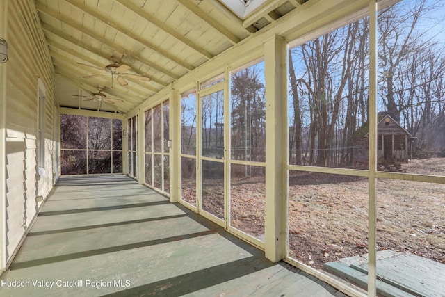 unfurnished sunroom featuring wood ceiling, ceiling fan, and lofted ceiling with beams