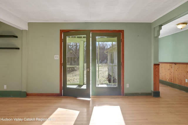 doorway featuring wooden walls and light hardwood / wood-style flooring