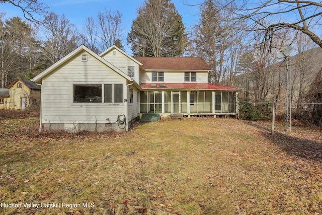 rear view of property with a yard and a sunroom