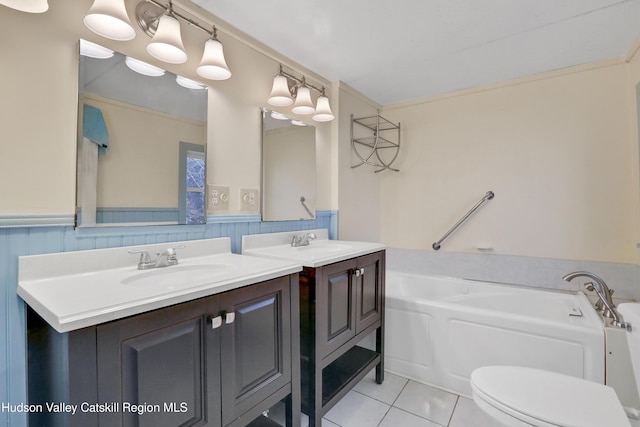 bathroom with tile patterned floors, vanity, toilet, and a bath