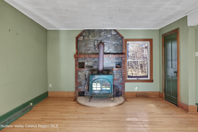 unfurnished living room featuring light hardwood / wood-style floors and a wood stove