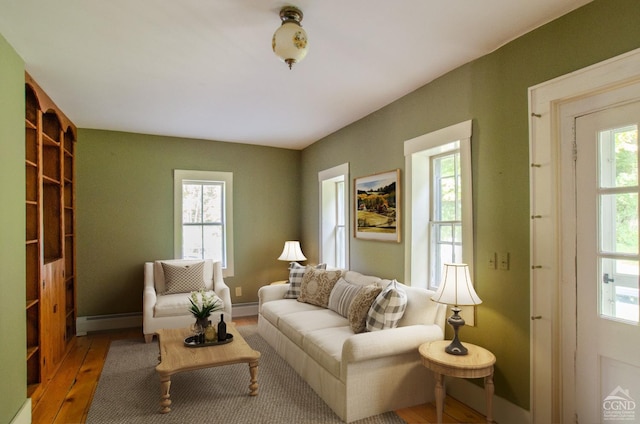 living area with baseboard heating and hardwood / wood-style flooring