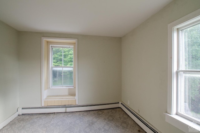 empty room featuring a baseboard heating unit and carpet flooring