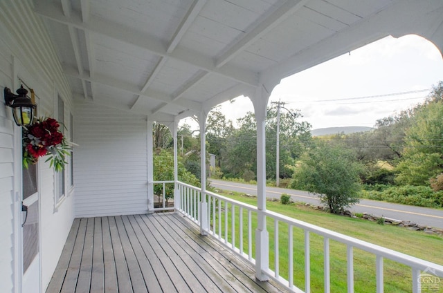 deck with a porch and a lawn