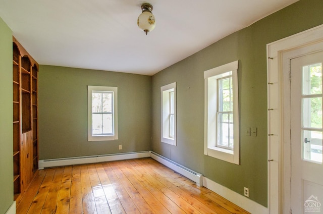 unfurnished room with light wood finished floors, a baseboard radiator, and baseboards
