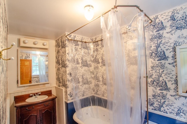 full bathroom with wallpapered walls, shower / bath combo with shower curtain, and vanity