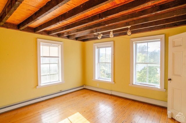 empty room with baseboard heating, wood-type flooring, and beamed ceiling