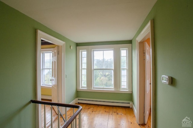 doorway to outside with a baseboard heating unit, hardwood / wood-style flooring, and baseboards
