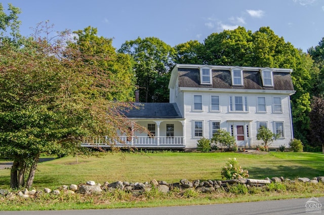 view of front facade featuring a front lawn, a porch, roof with shingles, and mansard roof