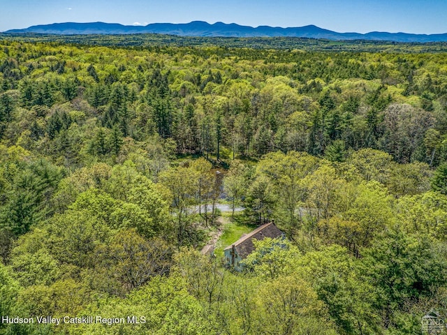 aerial view of a heavily wooded area and a mountainous background