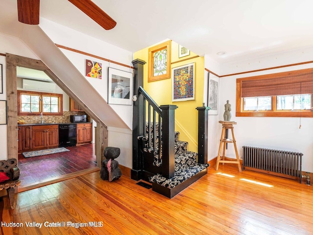 12 Library Ln, Woodstock, NY 12498 - staircase featuring radiator heating unit, wood-type flooring, a wall unit AC, and ceiling fan