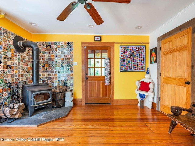 12 Library Ln, Woodstock, NY 12498 - foyer entrance featuring a ceiling fan, a wood stove, crown molding, and wood finished floors