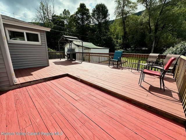 wooden deck with grilling area and outdoor dining space