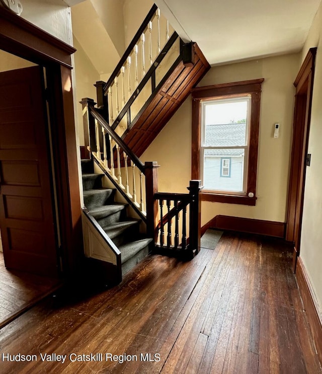 stairway featuring baseboards and wood finished floors